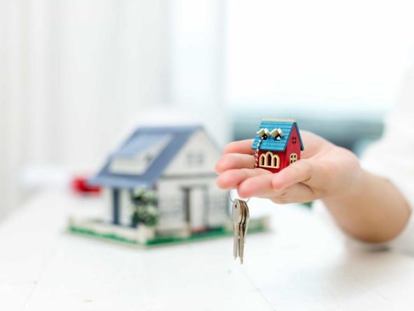 agencia inmobiliaria con un modelo de casa en escala pequeña